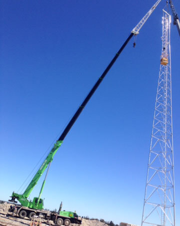Man basket work on a telecommunications tower using 85T slew crane with fly and needle